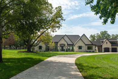 Large transitional gray one-story stone exterior home idea in Other with a shingle roof and a brown roof