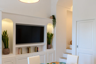 Immagine di una grande sala da pranzo aperta verso la cucina mediterranea con pareti bianche, pavimento con piastrelle in ceramica, pavimento beige e soffitto a volta