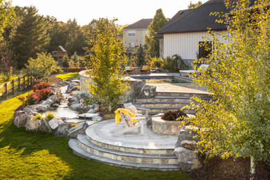 Inspiration for a large french country full sun backyard concrete paver landscaping in Denver with a fire pit.