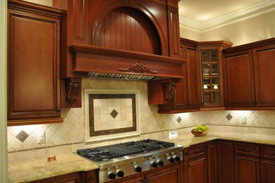 Inspiration for a large timeless u-shaped eat-in kitchen remodel in Detroit with raised-panel cabinets, granite countertops, beige backsplash, stainless steel appliances, dark wood cabinets, stone tile backsplash and an island