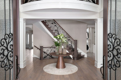 Entryway - large french country medium tone wood floor and brown floor entryway idea in Vancouver with white walls and a brown front door