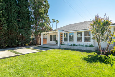 Transitional white one-story stucco house exterior idea in Los Angeles with a hip roof and a shingle roof