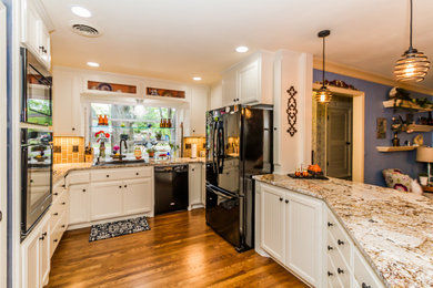 Mid-sized elegant galley light wood floor and brown floor kitchen pantry photo in Other with a drop-in sink, beaded inset cabinets, white cabinets, granite countertops, ceramic backsplash, black appliances, a peninsula and white countertops