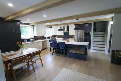 Large trendy l-shaped light wood floor, beige floor and exposed beam eat-in kitchen photo in Toronto with a farmhouse sink, recessed-panel cabinets, blue cabinets, quartz countertops, blue backsplash, subway tile backsplash, stainless steel appliances, an island and white countertops