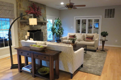 Family room - mid-sized transitional open concept light wood floor family room idea in DC Metro with gray walls, a standard fireplace, a stone fireplace and a wall-mounted tv