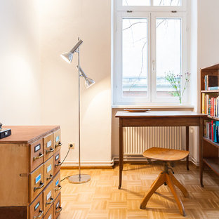 Foto de despacho tradicional renovado con paredes blancas, suelo de madera en tonos medios, escritorio independiente y suelo marrón
