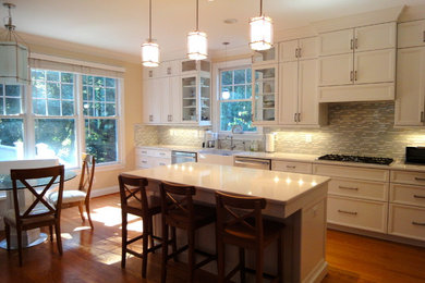 Large transitional l-shaped dark wood floor eat-in kitchen photo in DC Metro with a farmhouse sink, recessed-panel cabinets, white cabinets, quartzite countertops, multicolored backsplash, matchstick tile backsplash, stainless steel appliances and an island