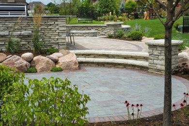 Design ideas for a large traditional backyard patio in Chicago with an outdoor kitchen and brick pavers.