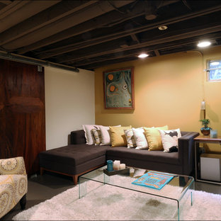 Photo of a small contemporary look-out basement in Portland with yellow walls, concrete flooring and no fireplace.