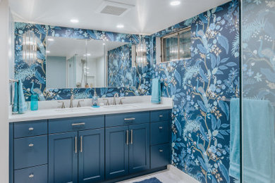 Inspiration for a large master white floor, double-sink and wallpaper corner shower remodel in Portland with flat-panel cabinets, blue cabinets, blue walls, an undermount sink, a hinged shower door, white countertops and a built-in vanity