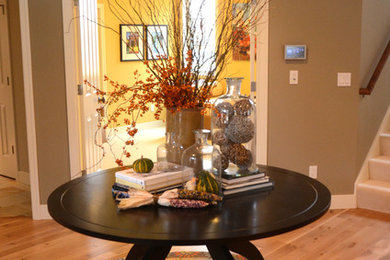 Entryway - mid-sized transitional light wood floor entryway idea in Grand Rapids with green walls and a white front door