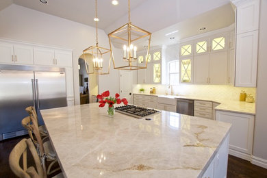 Huge trendy dark wood floor and brown floor eat-in kitchen photo in Other with a farmhouse sink, flat-panel cabinets, white cabinets, quartzite countertops, white backsplash, marble backsplash, stainless steel appliances and an island