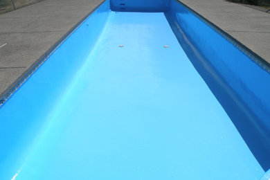 Modelo de piscina alargada contemporánea grande rectangular en patio con losas de hormigón