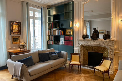 Inspiration for a large timeless formal and open concept light wood floor and coffered ceiling living room remodel in Paris with blue walls, a standard fireplace and a stone fireplace