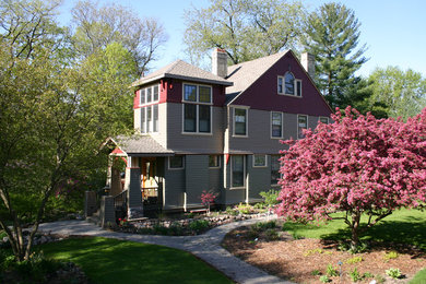 Example of a mid-sized arts and crafts red two-story wood exterior home design in Milwaukee with a shingle roof