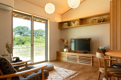 Ejemplo de salón abierto y beige con paredes beige, suelo de madera clara, televisor independiente y papel pintado