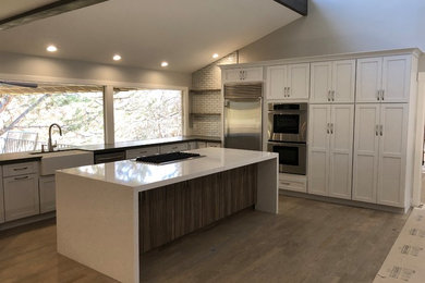 Large trendy u-shaped eat-in kitchen photo in Other with a farmhouse sink, shaker cabinets, white cabinets and an island