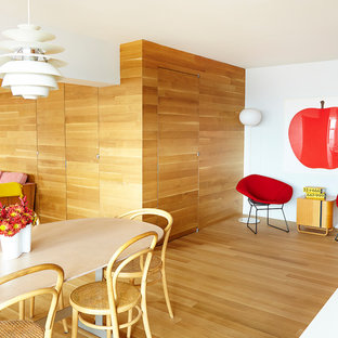 Exemple d'une salle à manger ouverte sur le salon moderne de taille moyenne avec un mur blanc et un sol en bois clair.