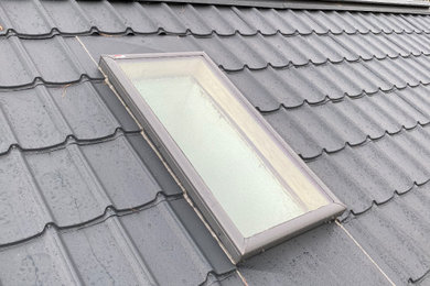 Example of an exterior home design in Toronto with a metal roof and a black roof