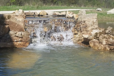 Photo of a large rustic full sun backyard stone landscaping in Chicago for summer.