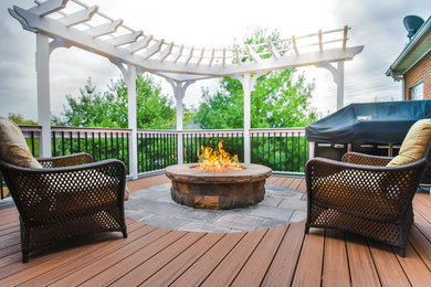 Mid-sized country backyard patio in Other with a fire feature, decking and a pergola.