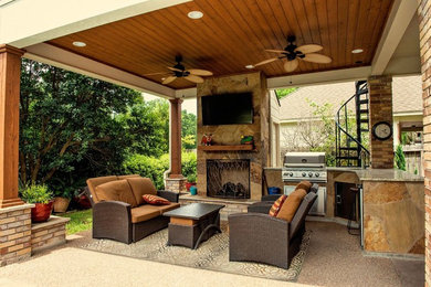 Photo of a large traditional backyard patio in Houston with with fireplace and a roof extension.