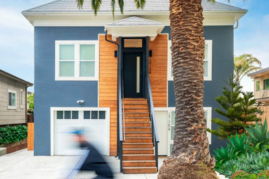 Mid-sized trendy blue three-story stucco house exterior photo in San Francisco with a clipped gable roof, a shingle roof and a gray roof