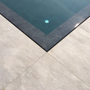 Piscina residenziale esterna con parete in vetro