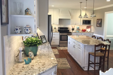 Enclosed kitchen - large traditional l-shaped dark wood floor and brown floor enclosed kitchen idea in Richmond with raised-panel cabinets, white cabinets, granite countertops, white backsplash, ceramic backsplash, stainless steel appliances and an island
