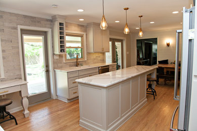Photo of a large arts and crafts u-shaped eat-in kitchen in Indianapolis with an undermount sink, recessed-panel cabinets, grey cabinets, quartz benchtops, green splashback, glass tile splashback, stainless steel appliances, medium hardwood floors, with island and brown floor.