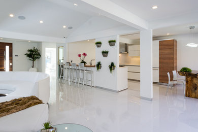 This is an example of a small modern galley eat-in kitchen in Los Angeles with an undermount sink, flat-panel cabinets, white cabinets, quartzite benchtops, stainless steel appliances, no island and white floor.
