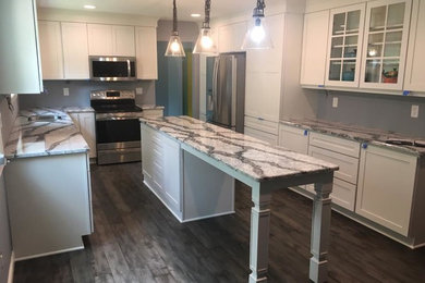 Inspiration for a mid-sized transitional galley gray floor eat-in kitchen remodel in Detroit with white cabinets, stainless steel appliances and an island