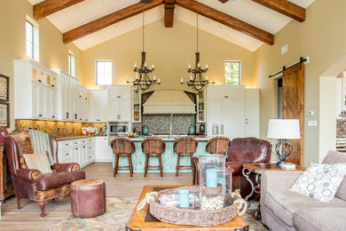 Inspiration for a mediterranean l-shaped medium tone wood floor open concept kitchen remodel in Austin with shaker cabinets, white cabinets, multicolored backsplash, mosaic tile backsplash and an island