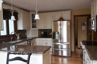 Eat-in kitchen - mid-sized traditional u-shaped medium tone wood floor eat-in kitchen idea in Indianapolis with a double-bowl sink, raised-panel cabinets, white cabinets, granite countertops, beige backsplash, matchstick tile backsplash, stainless steel appliances and a peninsula