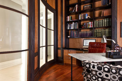 Large contemporary home office in Detroit with a library, brown walls, medium hardwood floors, a freestanding desk and brown floor.