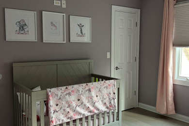 Design ideas for a large transitional nursery for girls in Chicago with purple walls and light hardwood floors.
