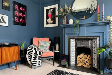 Идея дизайна: гостиная комната среднего размера в викторианском стиле с синими стенами, ковровым покрытием, стандартным камином, фасадом камина из дерева, отдельно стоящим телевизором и бежевым полом