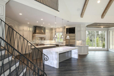 Kitchen pantry - huge modern l-shaped dark wood floor, brown floor and vaulted ceiling kitchen pantry idea in New York with an integrated sink, louvered cabinets, beige cabinets, quartzite countertops, beige backsplash, granite backsplash, colored appliances, a peninsula and turquoise countertops