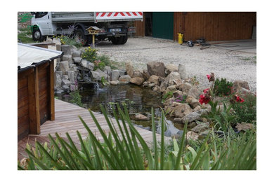 Идея дизайна: маленький садовый фонтан на переднем дворе с настилом для на участке и в саду