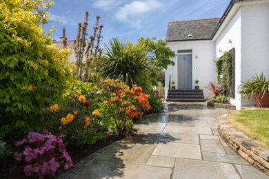 На фото: участок и сад на переднем дворе в современном стиле с полуденной тенью и покрытием из каменной брусчатки с