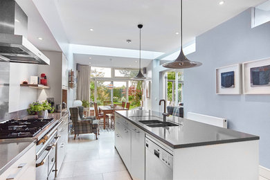 Inspiration for a modern galley eat-in kitchen in Dublin with an integrated sink, flat-panel cabinets, white cabinets, quartz benchtops and with island.