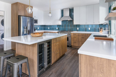 Large minimalist u-shaped vinyl floor and brown floor eat-in kitchen photo in Los Angeles with a single-bowl sink, flat-panel cabinets, brown cabinets, quartz countertops, blue backsplash, ceramic backsplash, stainless steel appliances, an island and white countertops