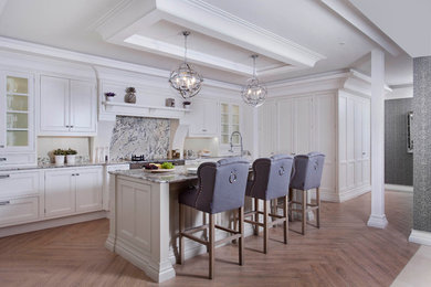 Photo of a large classic l-shaped enclosed kitchen in Dublin with a submerged sink, louvered cabinets, beige cabinets, granite worktops, multi-coloured splashback, stone slab splashback, stainless steel appliances, porcelain flooring, an island and brown floors.