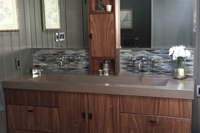 Mid-sized elegant master multicolored tile and mosaic tile porcelain tile doorless shower photo in Philadelphia with concrete countertops, flat-panel cabinets, medium tone wood cabinets, a two-piece toilet, gray walls and an integrated sink