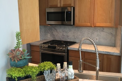 Inspiration for a small galley vinyl floor and gray floor kitchen remodel in Seattle with an undermount sink, shaker cabinets, light wood cabinets, quartz countertops, gray backsplash and stainless steel appliances