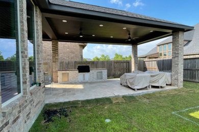 Foto de patio grande en patio trasero y anexo de casas con cocina exterior y losas de hormigón