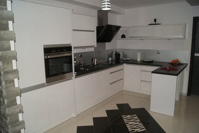 L Küche in weiß mit schwarzer Arbeitsplatte und Edelstahl Rückwand