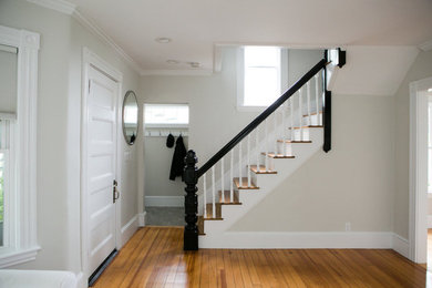 Mid-sized transitional light wood floor and brown floor entryway photo in Manchester with beige walls and a white front door