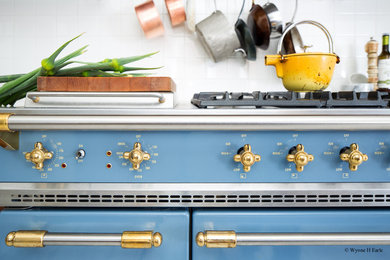 Inspiration for a transitional galley terra-cotta tile kitchen remodel in Seattle with a farmhouse sink, flat-panel cabinets, dark wood cabinets, marble countertops, white backsplash, ceramic backsplash and colored appliances