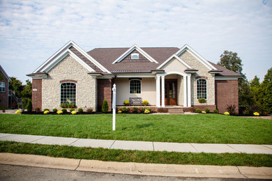 Large traditional brown one-story brick house exterior idea in Louisville with a shingle roof